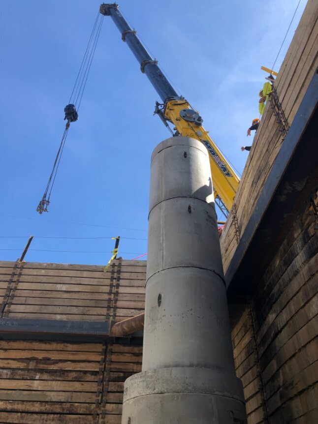 crane moving cement pipes